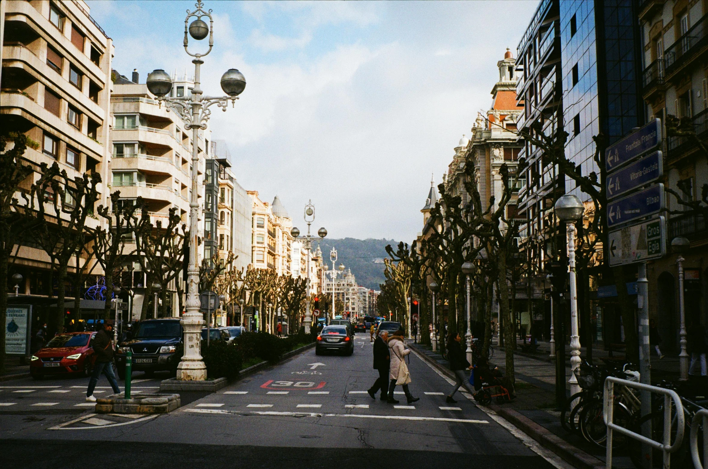 a couple is walking across the street near buildings