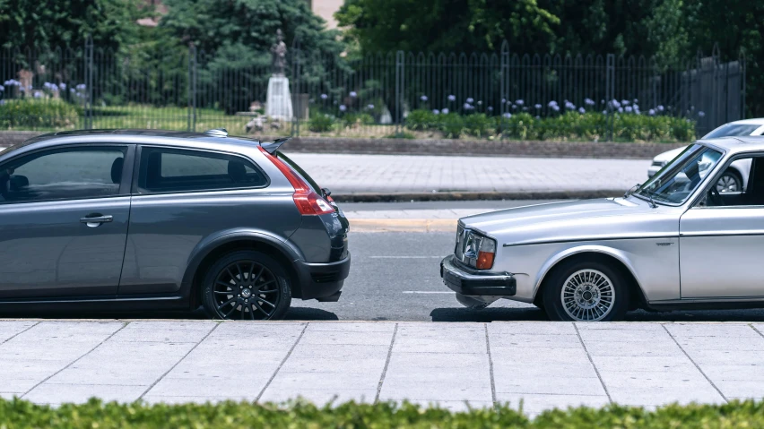 two cars stopped on the curb near a public road