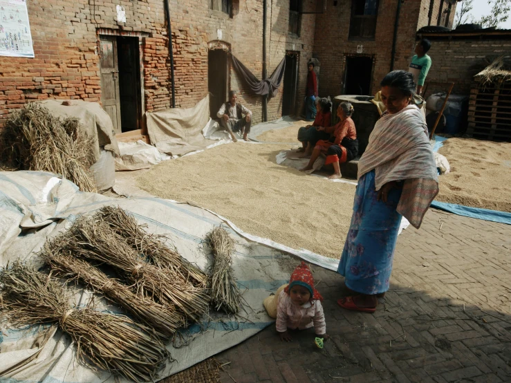 a mother and daughter looking at various bundles of straw