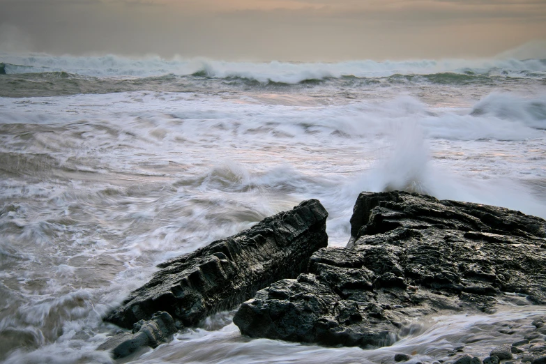 an ocean view with rough waves and rocks