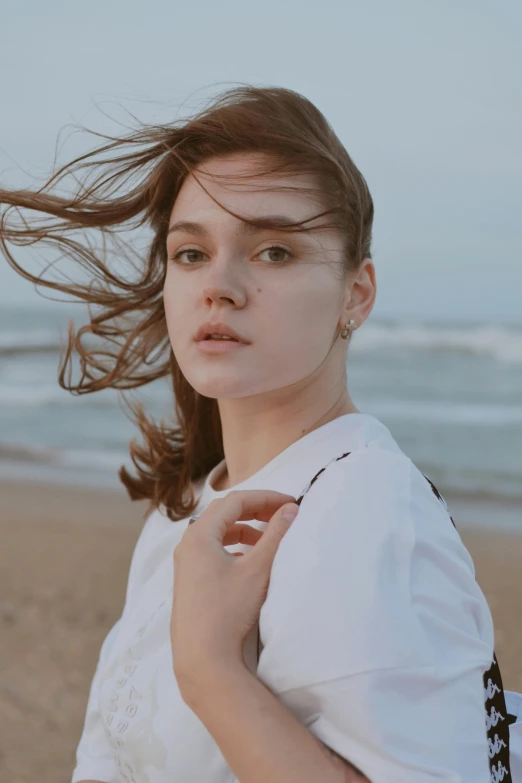 a girl standing at the ocean's edge in front of a body of water