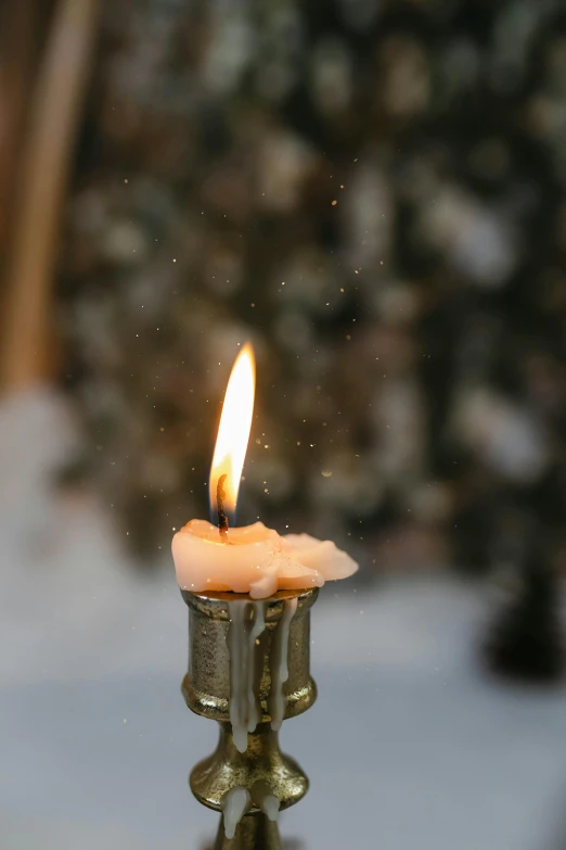 a candle light is on a table with snow