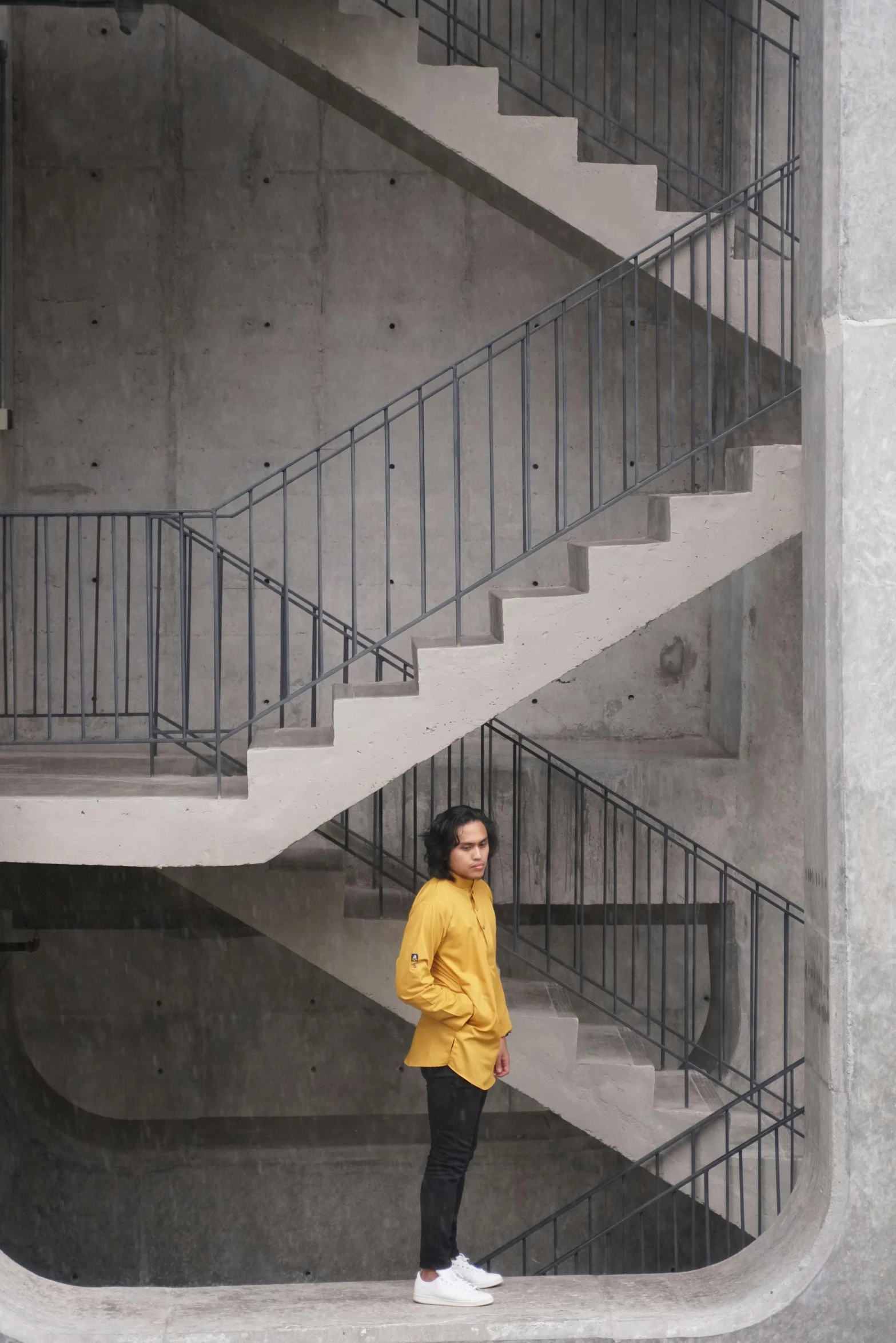 woman standing in front of stairs while looking at her cell phone