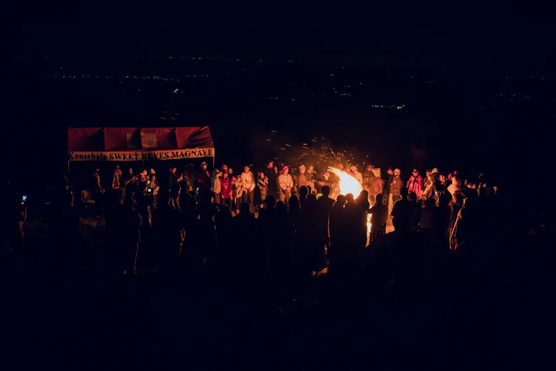 people around the fire in a dark area with many red flags