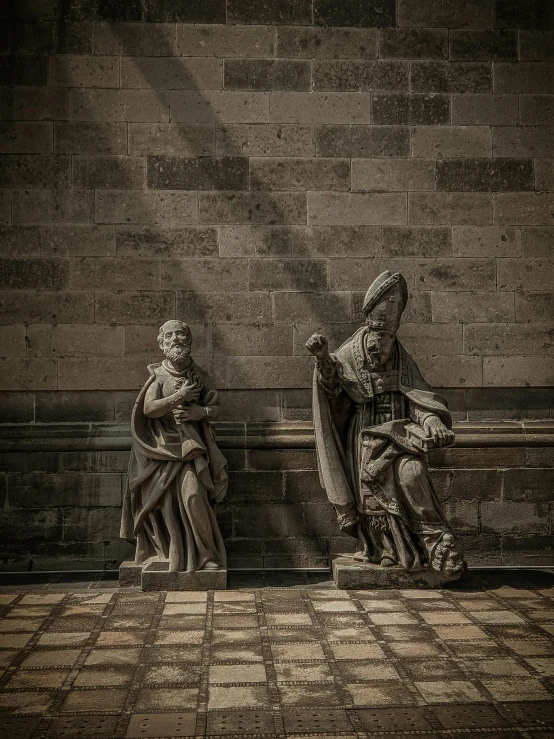 two statues sitting next to each other on a checkered floor