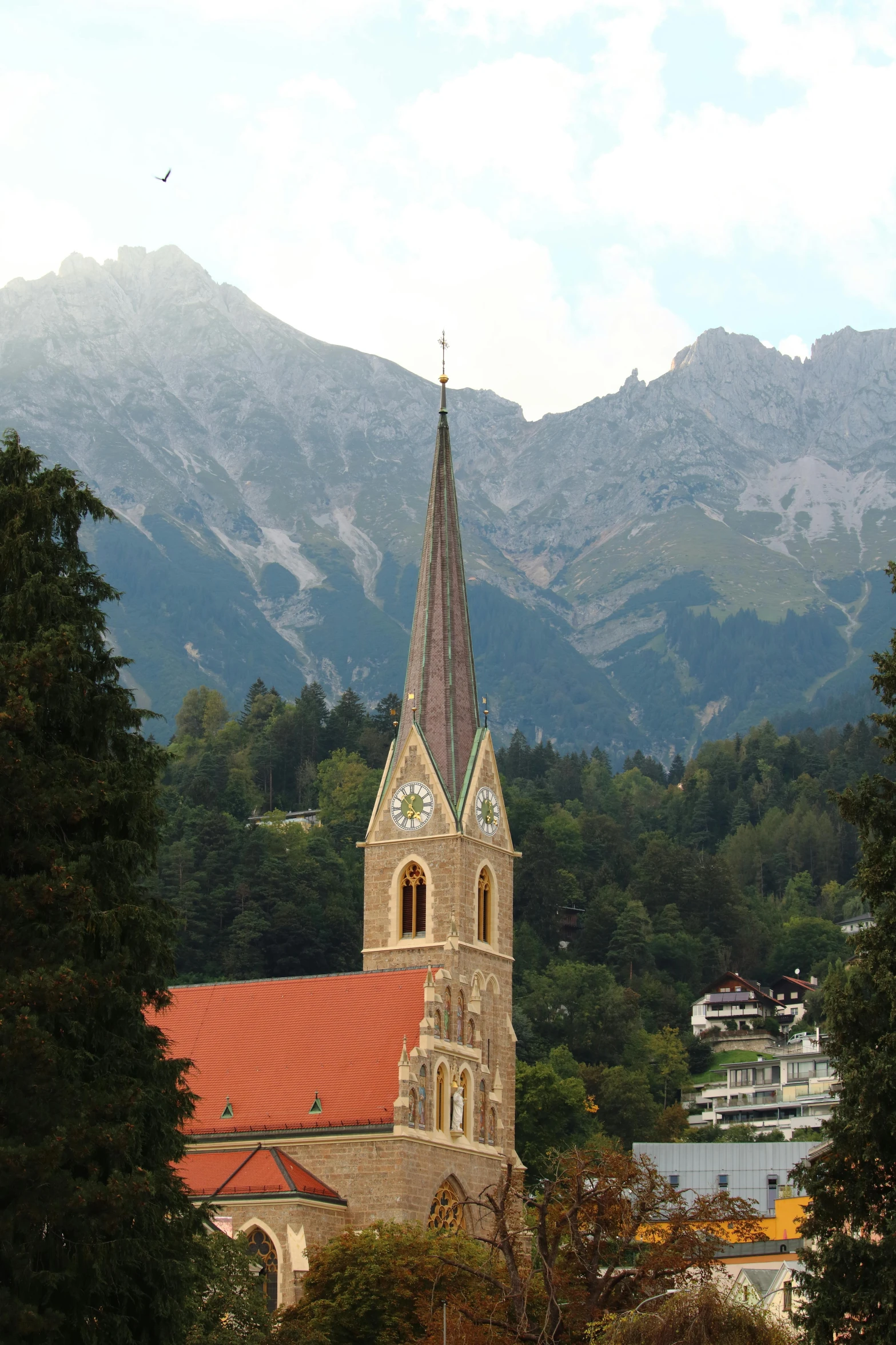 a tall church tower near the mountains in front of it