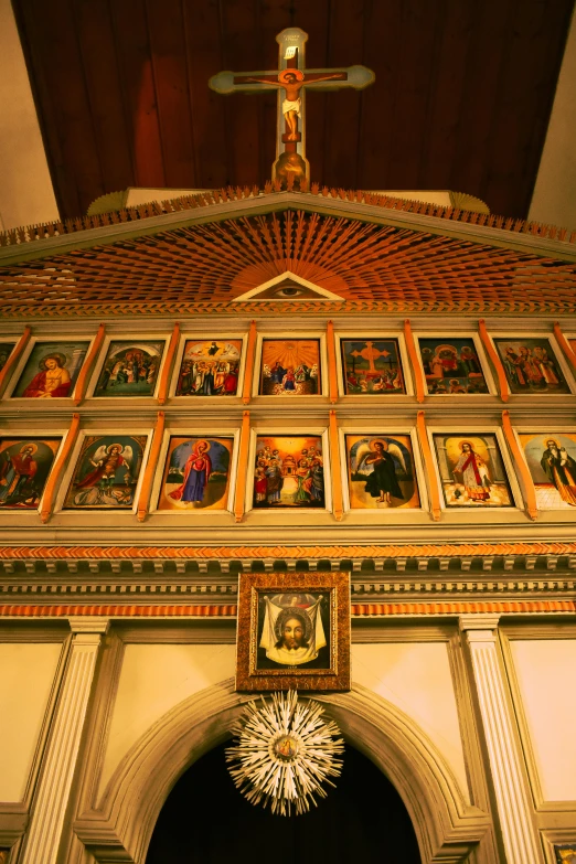 an elaborate archway adorned with religious paintings, candles and a cross