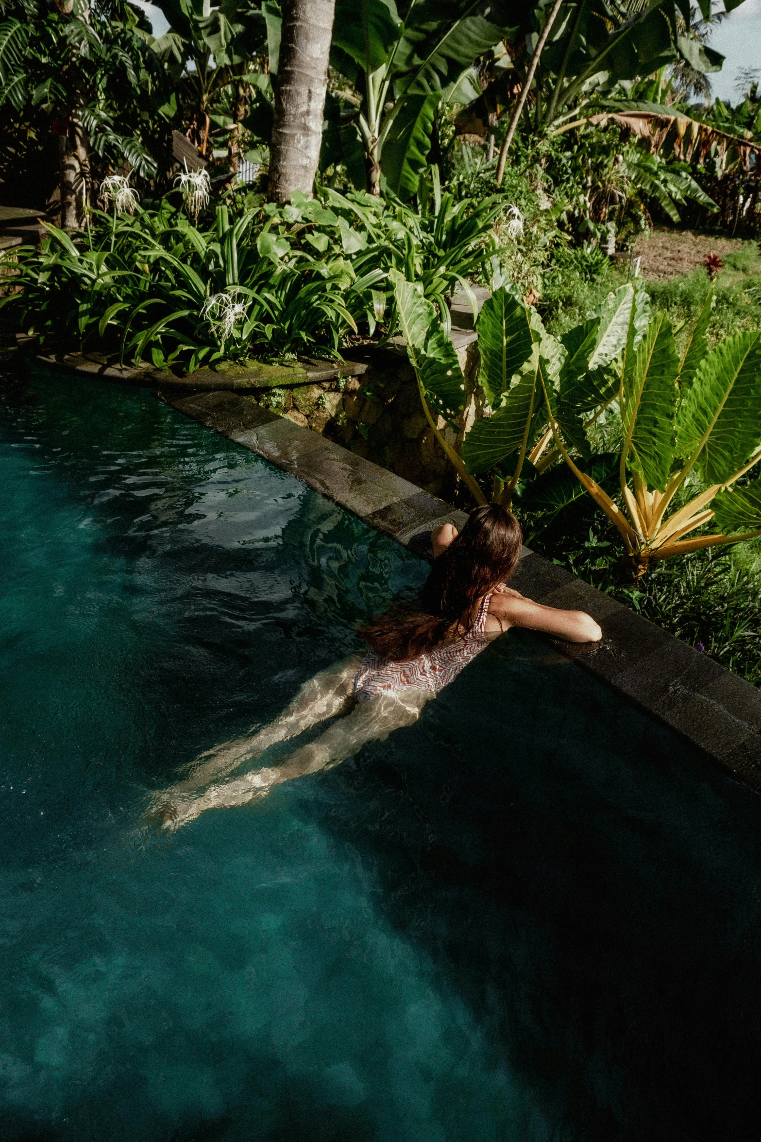 a girl laying down on the ground in a pool