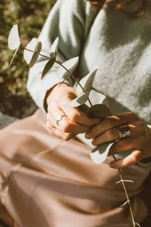 a woman sitting down holding soing up to her finger