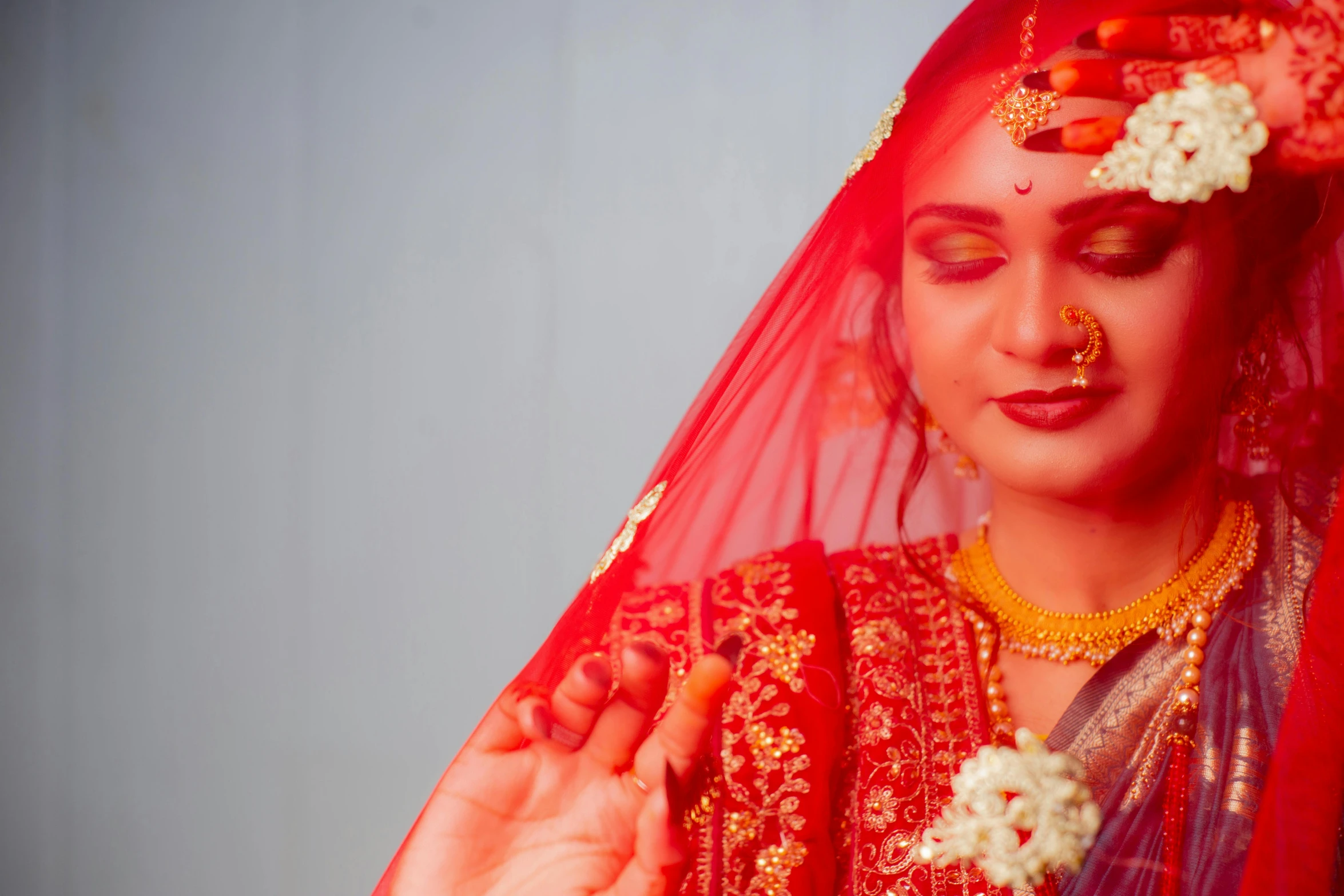 a woman dressed in traditional garb holding flowers and jewelry