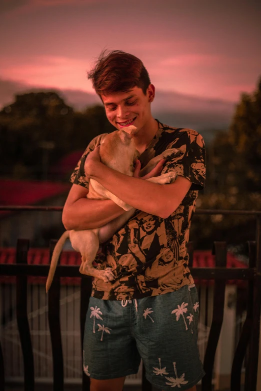 man holding his dog on his arms while smiling