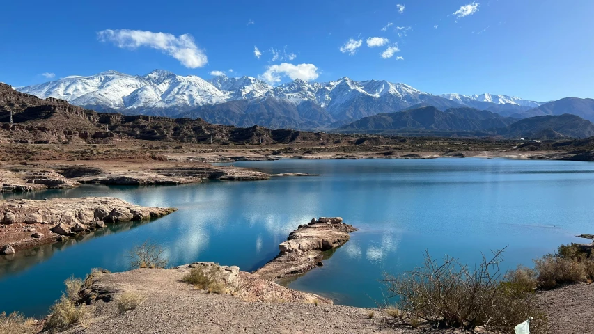 a body of water surrounded by mountains and sand