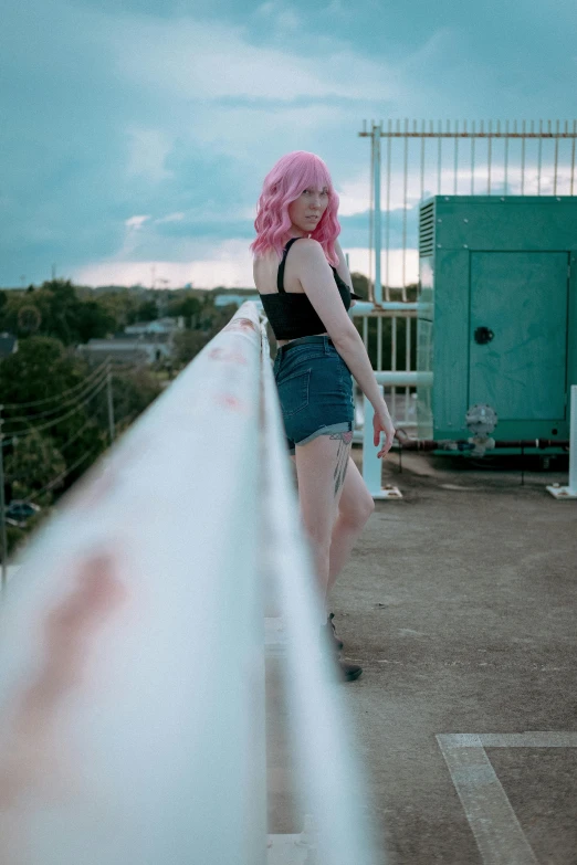 woman with pink hair on top of a building