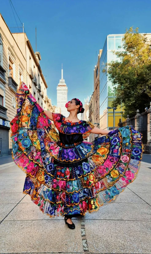 the woman is wearing a colorful frock that has been made of flowers