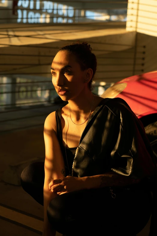 a girl with a  shirt is sitting in front of her car