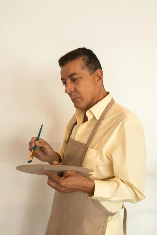 a man holding a paper with a green pencil in his pocket