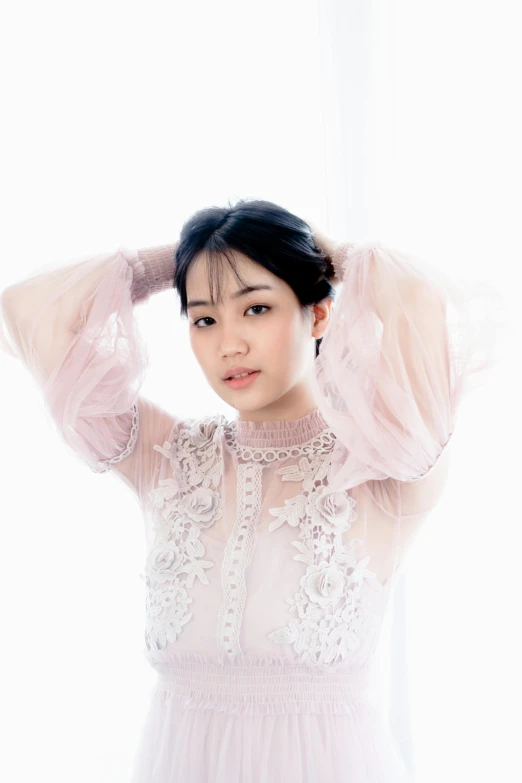 asian woman wearing a pink tulle top and pearls