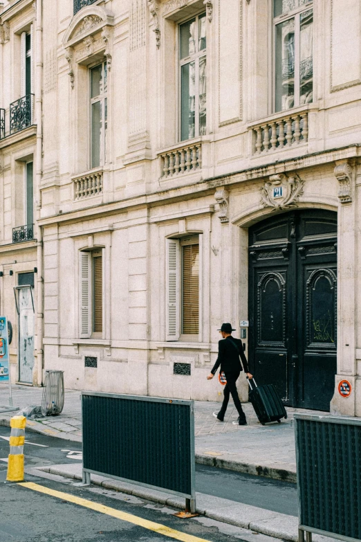 a man walks down a street past a building