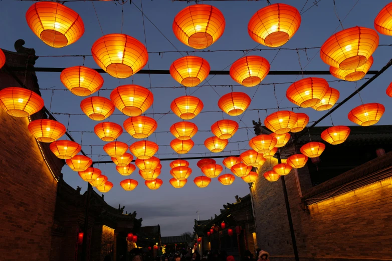 lanterns are hung above the walkway in an asian village