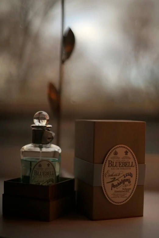a bottle of perfume on a table with a box next to it