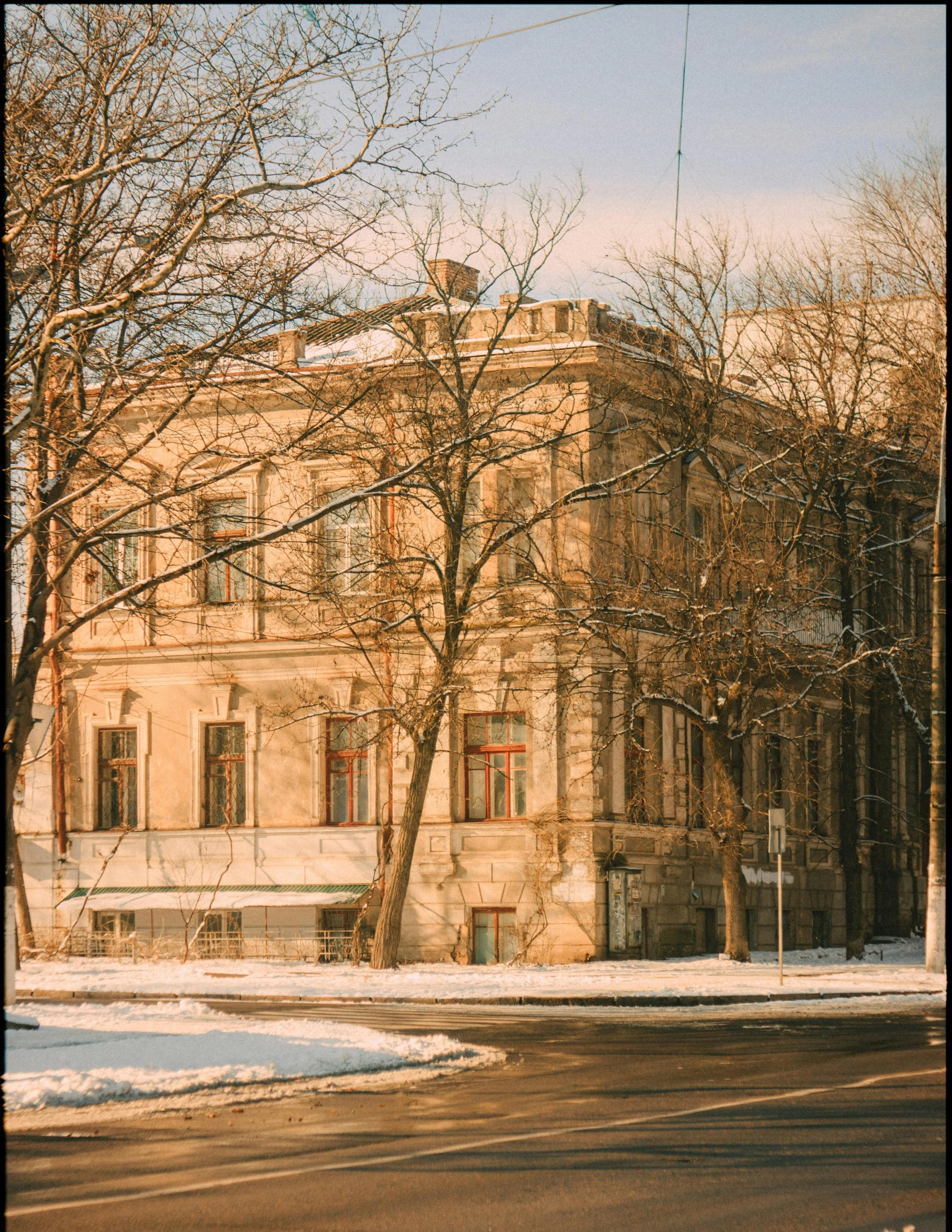 a snow covered road leading to an old fashioned building