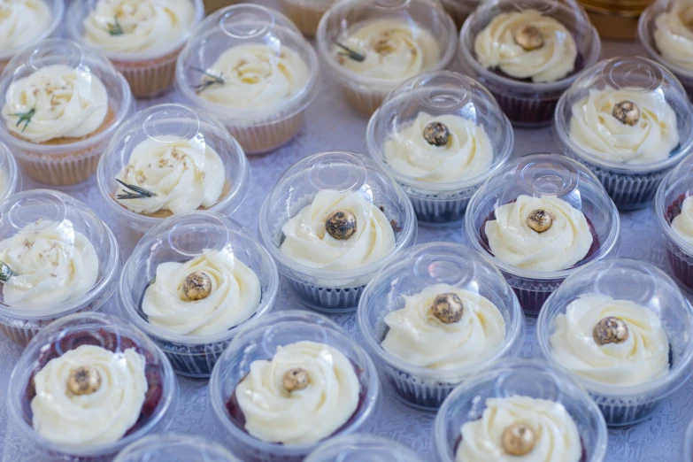 an assortment of cup cakes with cream icing on top of them