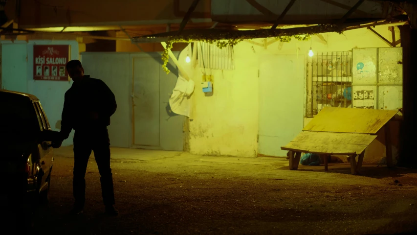 the man is standing near a car in a garage