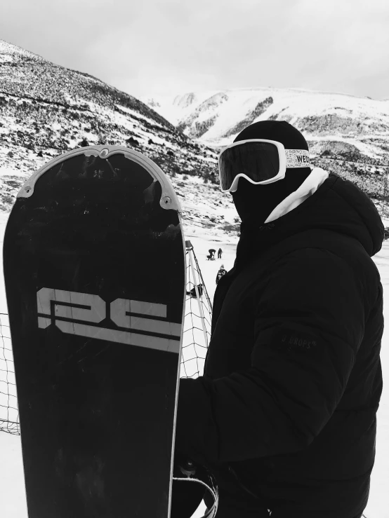 a man is holding his snowboard as he stands in the snow