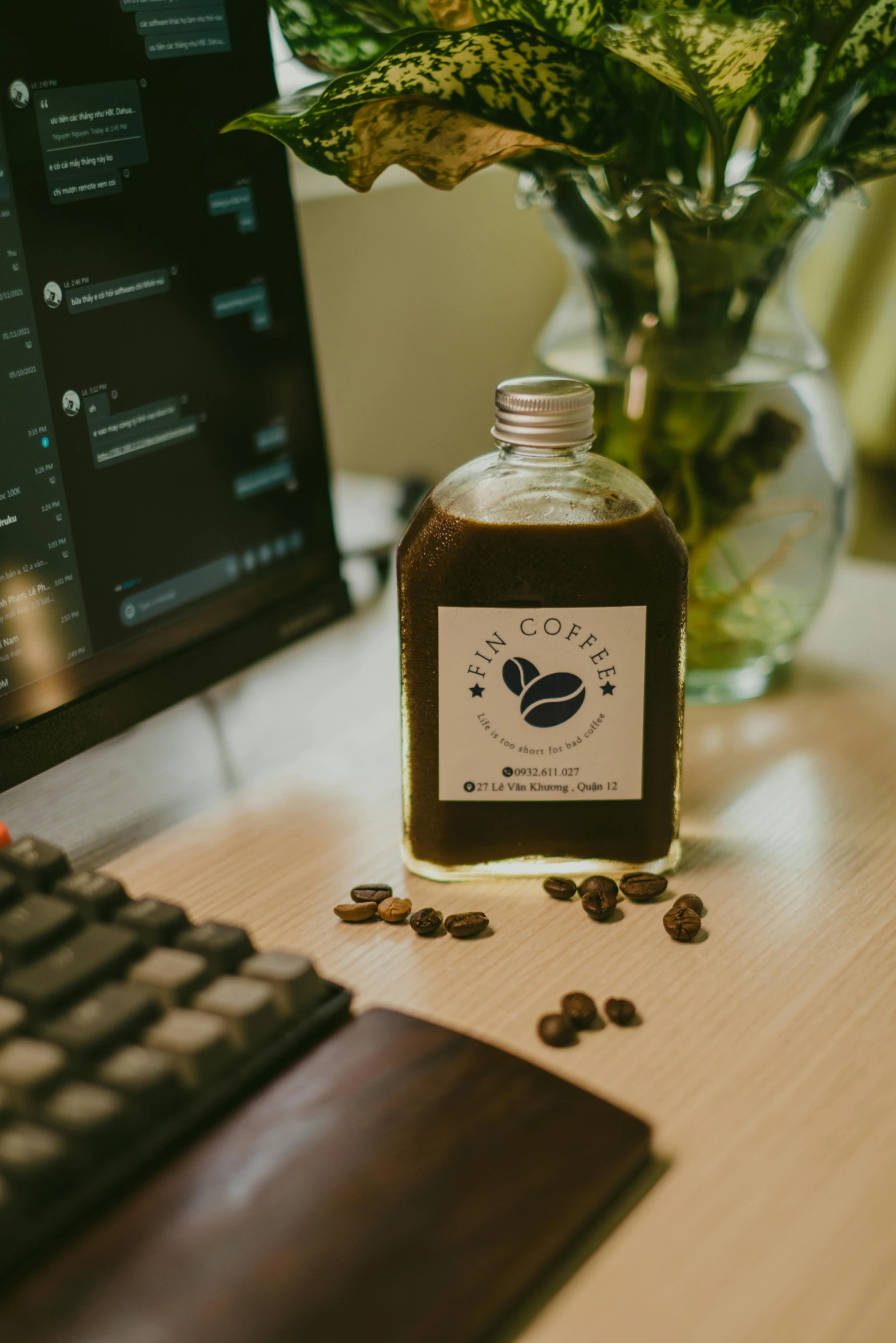 a coffee bottle sitting on a table next to a computer