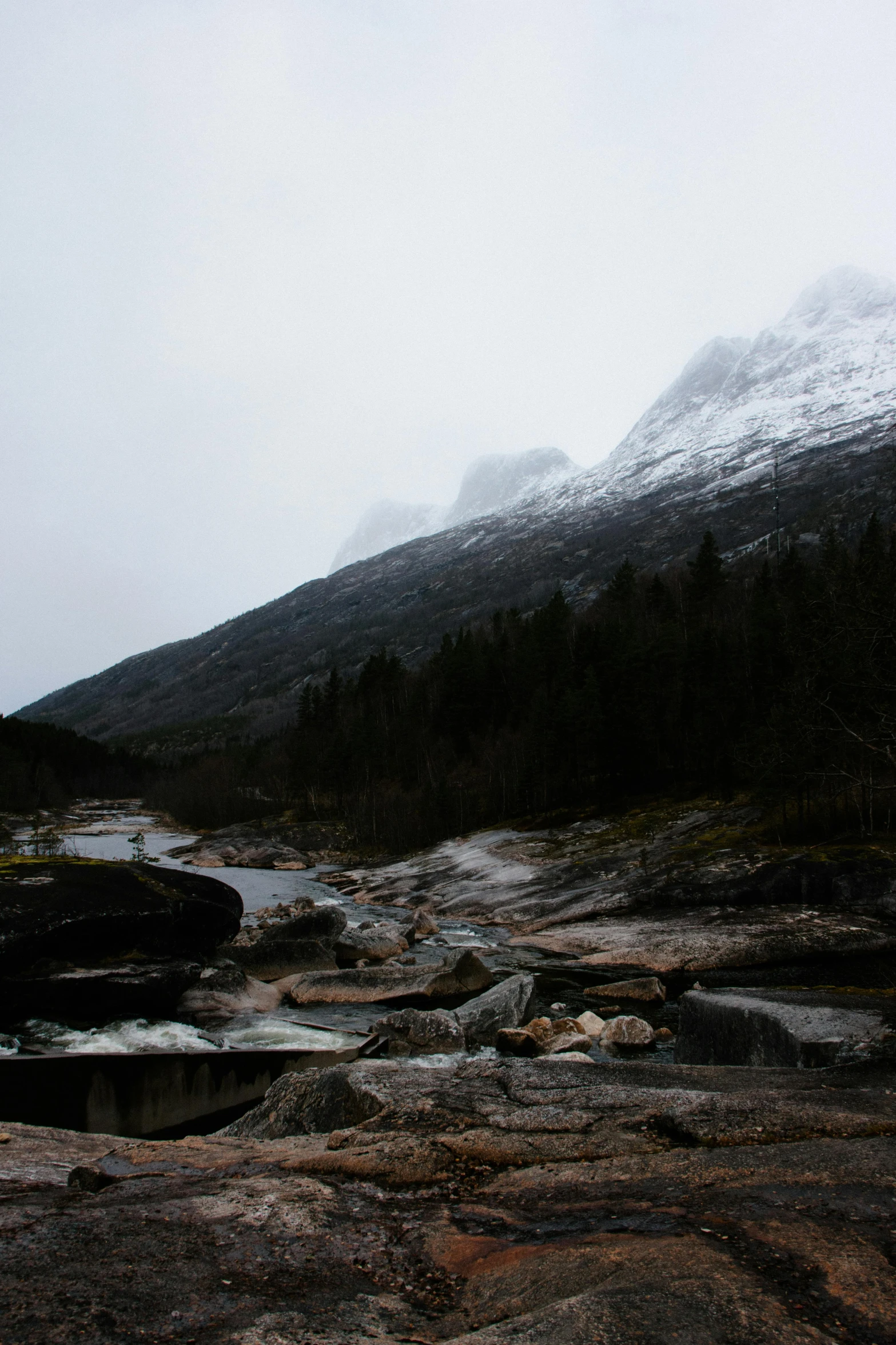 snow covered mountains in the background and a river in the foreground