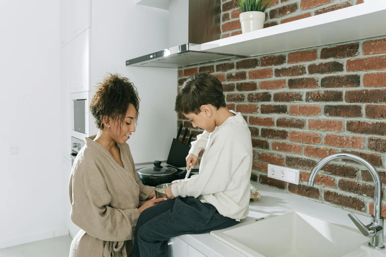 a woman talking to another women sitting on a counter