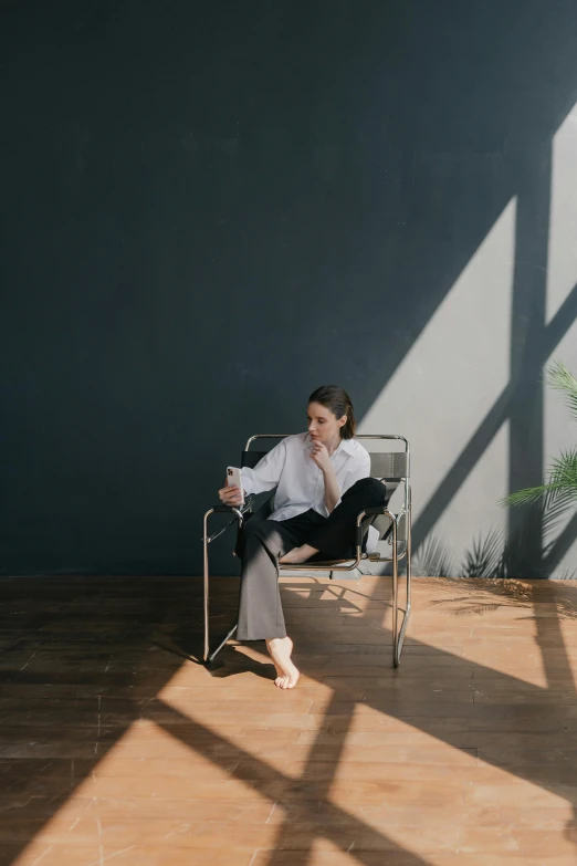 a woman sitting in a chair in an empty room