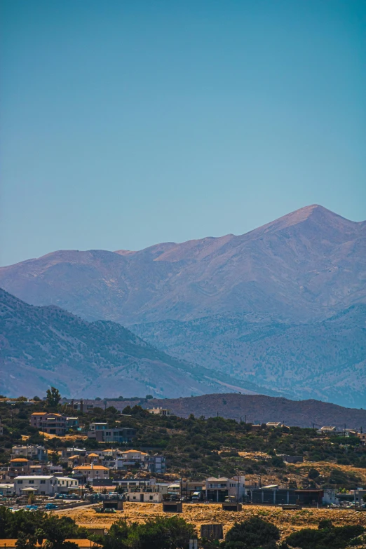 a small town sits on a hill overlooking the mountains