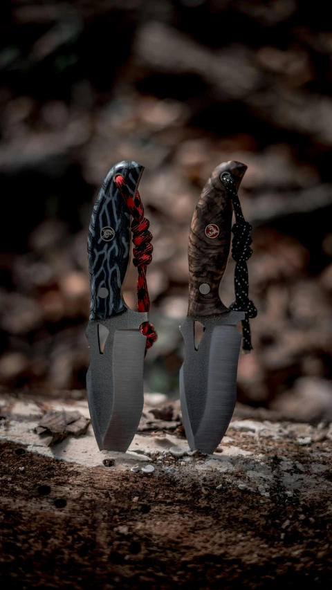 two knives with a very sharp blade sitting on a rock