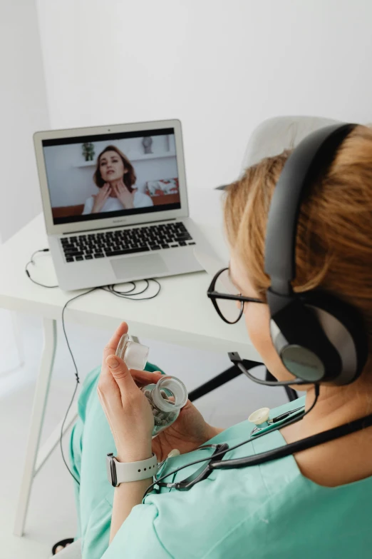 a woman with headphones watching soing on her computer