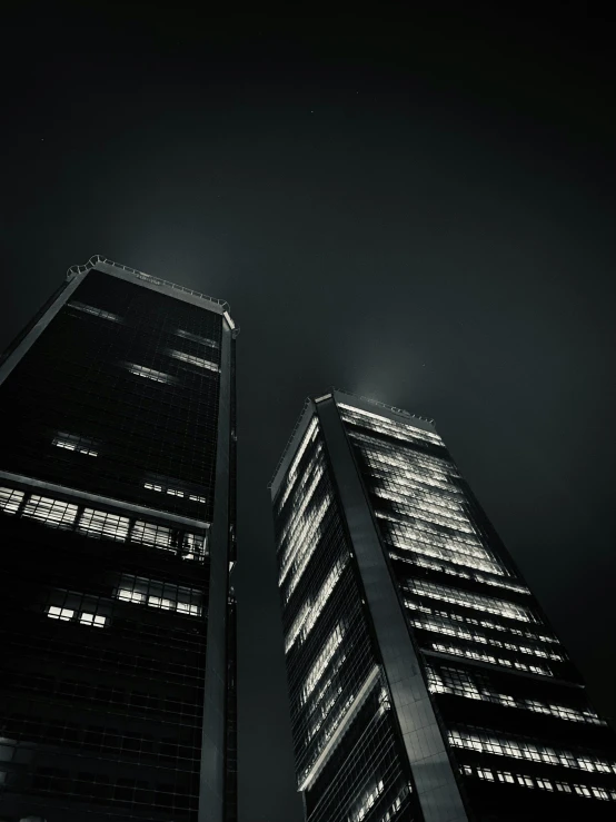 two very tall buildings are shown at night