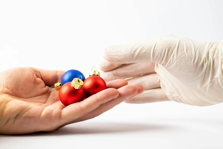 two hands holding ornaments near each other