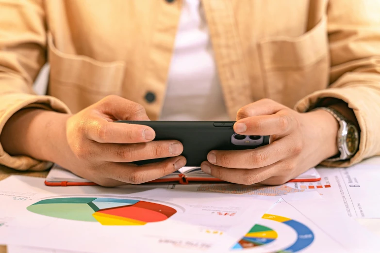 a person is working with his smartphone while on the table