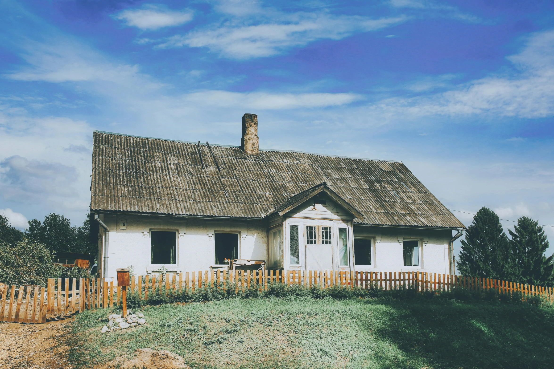 a picture of a white cottage in the country