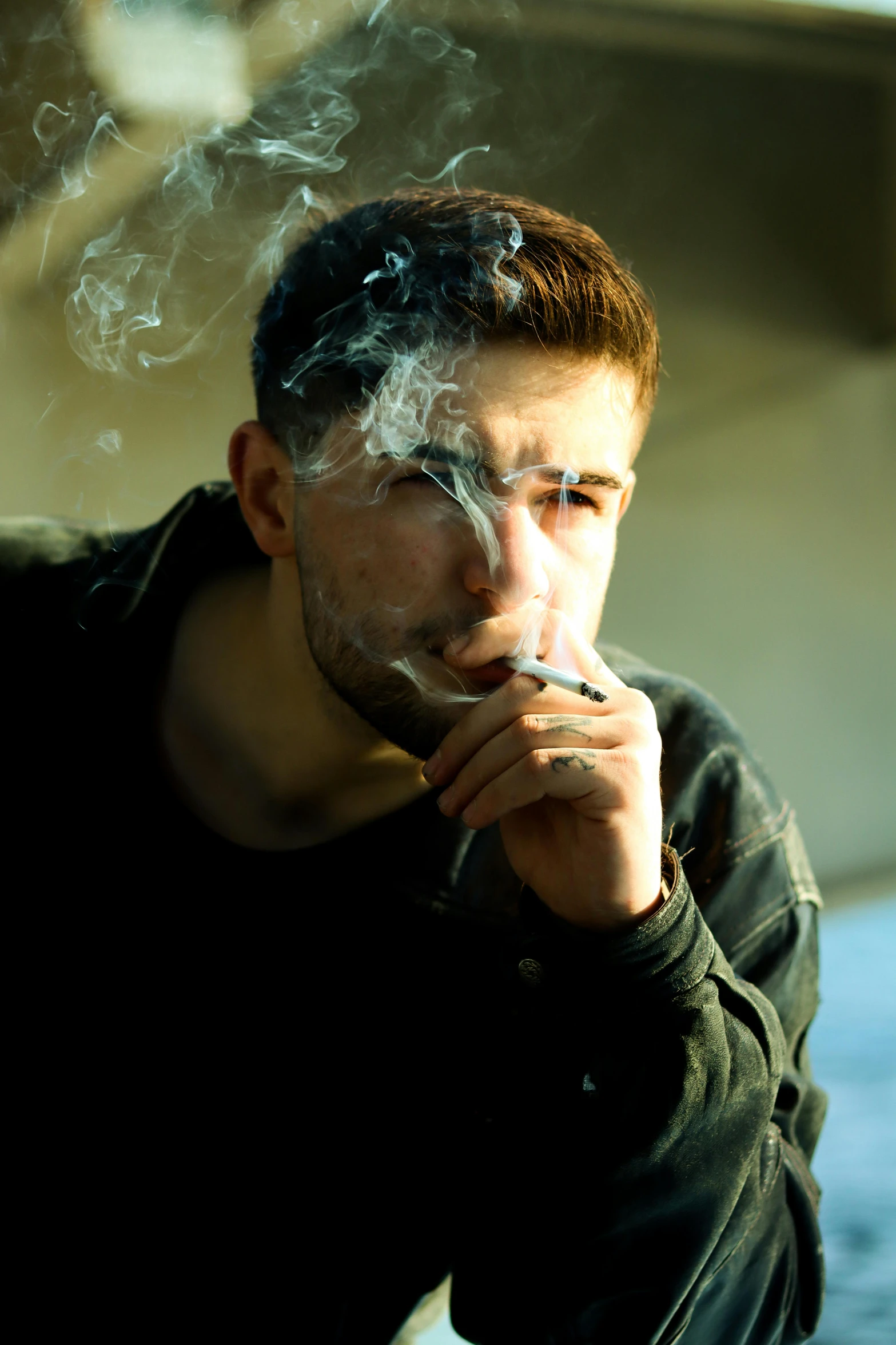 a man smoking a cigarette sitting at a table