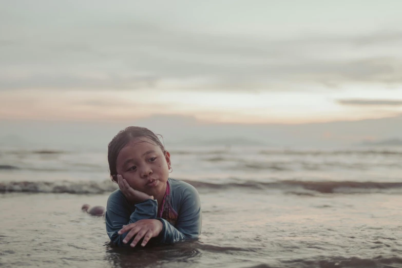 a person laying in the ocean on their belly