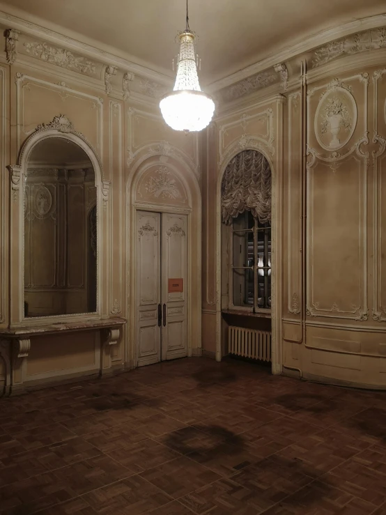 an empty ballroom that is well lit by a chandelier