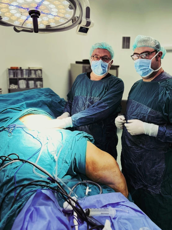 a group of doctors in scrubs standing around an iv tube