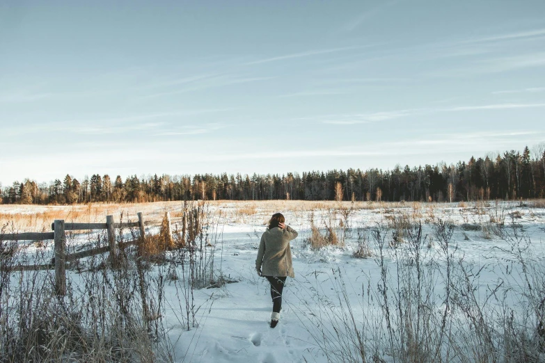 a person walking through snowy area surrounded by trees