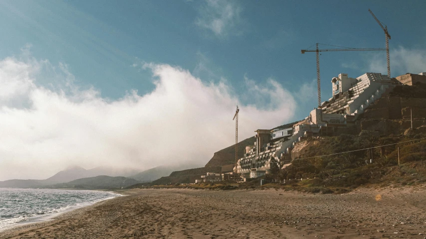 a picture of a beach near the ocean with houses on top