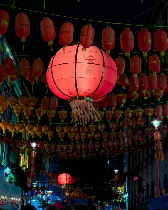 large lanterns on strings above a street at night