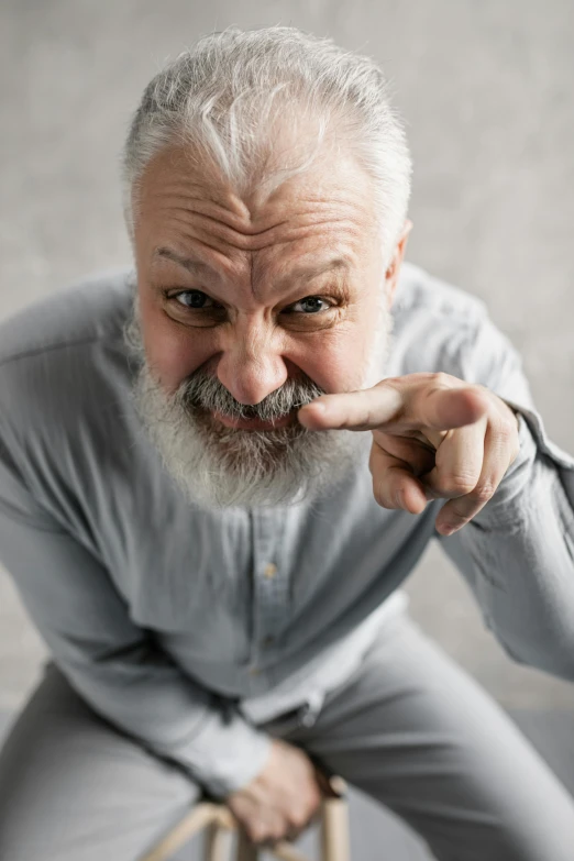 an old man poses for a picture with the hand on his face