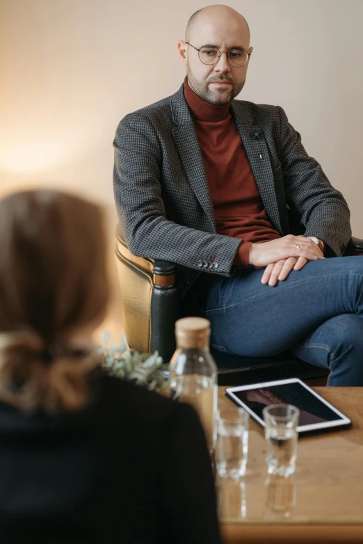 a man sits in a chair in front of a table