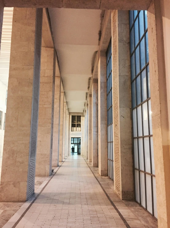 an empty hallway leads to a building with windows