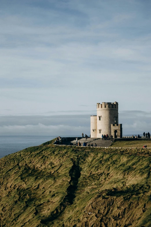 a long tower sitting on top of a hill with people in it